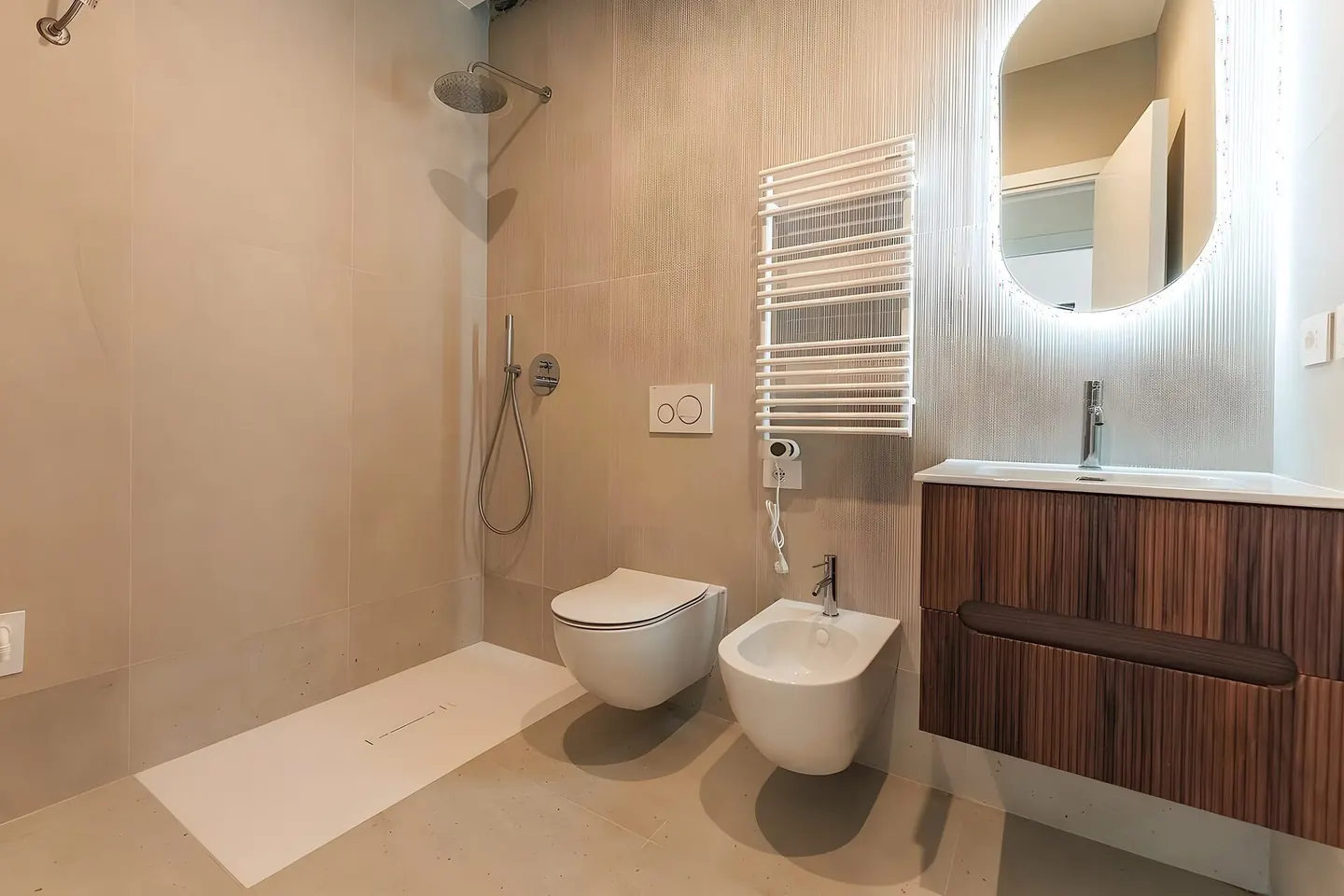Baño reformado en Granollers con ducha de obra, alicatado blanco y mueble suspendido