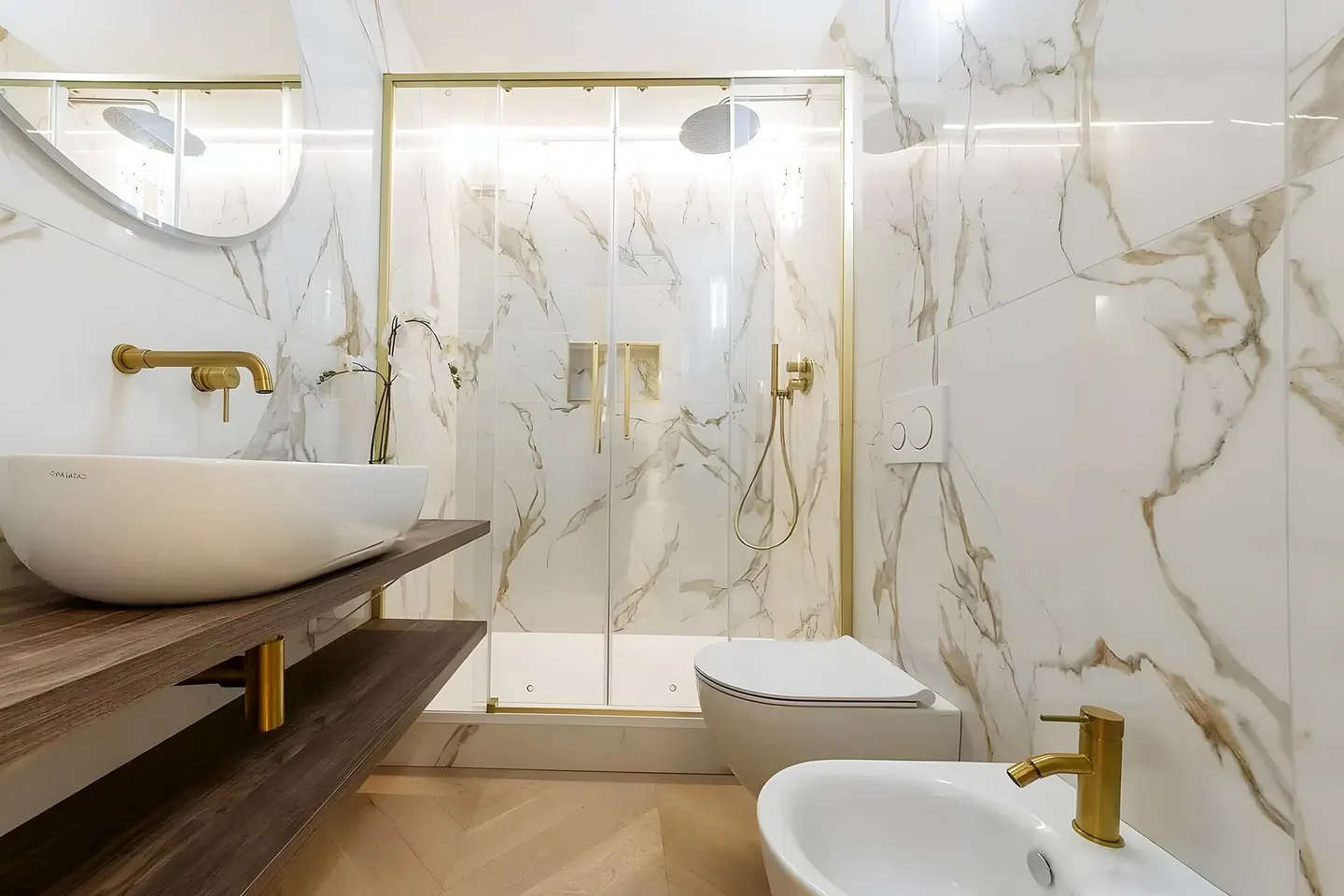 Baño premium con mármol calacatta y grifería dorada en Les Franqueses del Vallès