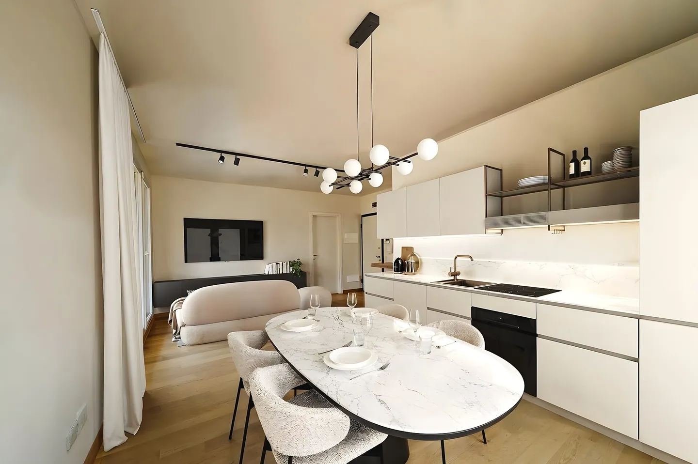 Cocina abierta al comedor con isla de mármol e iluminación de diseño