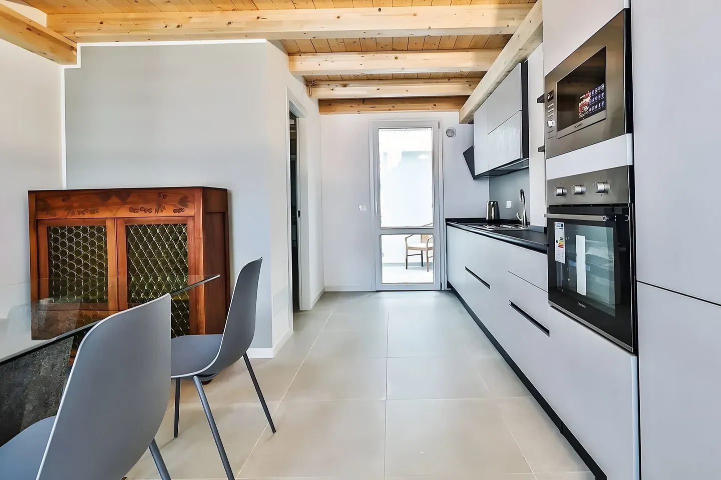 Cocina con isla de madera abierta al comedor en una casa reformada en Les Franqueses del Vallès
