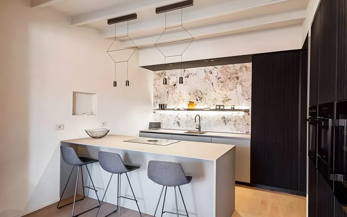 Cocina abierta con isla y taburetes tras una reforma en Lledoner, Granollers