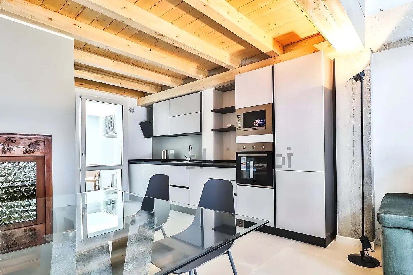 Salón cálido de una vivienda reformada en el Vallès Oriental, con luz natural y acabados en madera